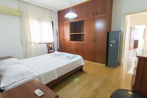 a bedroom with a bed and a wooden cabinet at Peanut House by HolidayKeys in Kérynia
