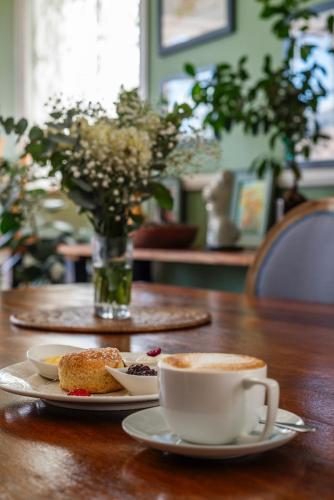a table with two plates of food and cups of coffee at The Willets Boutique Hotel in Simon's Town in Simonʼs Town