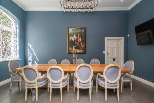 a dining room with a wooden table and chairs at The Willets Boutique Hotel in Simon's Town in Simonʼs Town