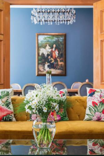a couch with a vase of flowers on a table at The Willets Boutique Hotel in Simon's Town in Simonʼs Town
