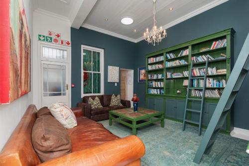 a living room with a couch and book shelves at The Willets Boutique Hotel in Simon's Town in Simonʼs Town