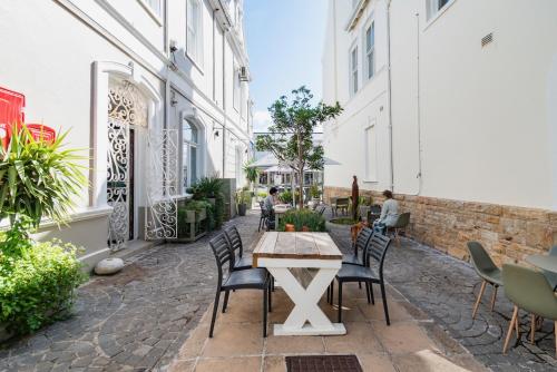 a patio with a table and chairs on a sidewalk at The Willets Boutique Hotel in Simon's Town in Simonʼs Town