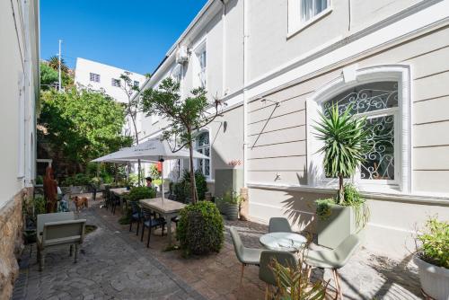 a patio with tables and chairs next to a building at The Willets Boutique Hotel in Simon's Town in Simonʼs Town