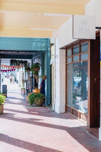 a woman walking down a sidewalk in front of a store at The Willets Boutique Hotel in Simon's Town in Simonʼs Town