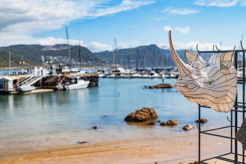 a sculpture of a cat head on the shore of a marina at The Willets Boutique Hotel in Simon's Town in Simonʼs Town