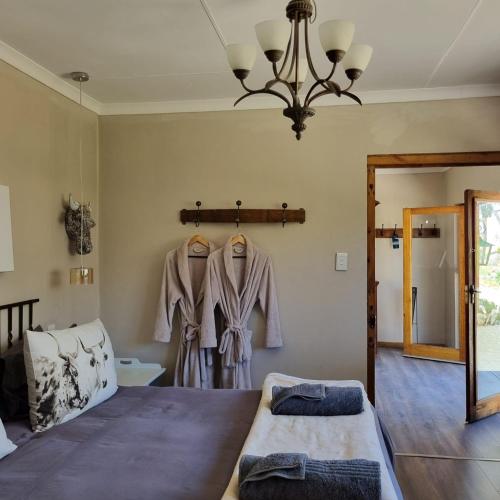 a bedroom with two beds and a chandelier at The Fat Mulberry Guest Farm in Fouriesburg