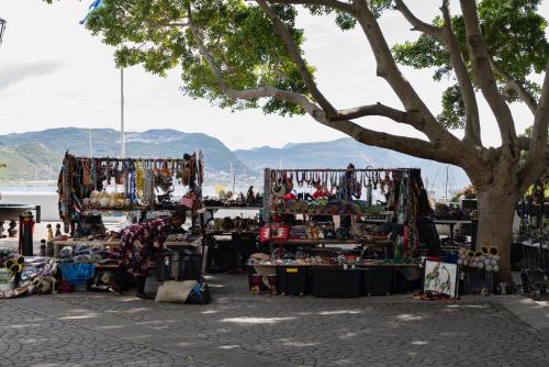 a market with a lot of merchandise in front of a tree at The Willets Boutique Hotel in Simon's Town in Simonʼs Town