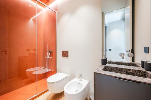 a bathroom with a toilet and a sink and a shower at Terrazza con Jacuzzi e Vista Iconica sul Duomo in Milan
