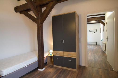 a bedroom with a bed and a tall cabinet at NEU! FeWo Märchenstube in Alsfeld
