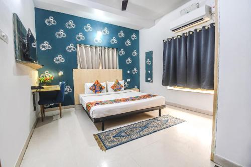 una camera da letto con un letto e una parete blu di FabHotel Welcome Inn I a Khandagiri