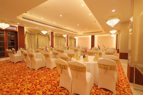 a banquet hall with white tables and chairs and chandeliers at Regenta Orko's Haridwar, Motichur, 10 min from Har ki Pauri in Haridwār
