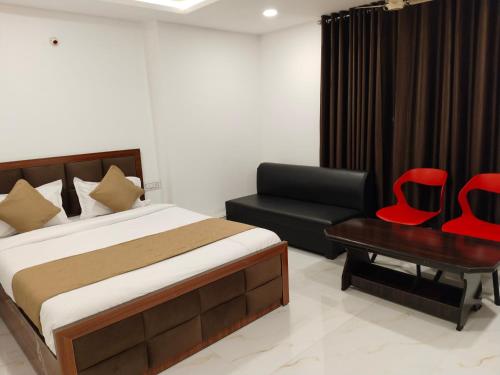 a bedroom with a bed and a chair and a desk at Hotel Shiv in Indore