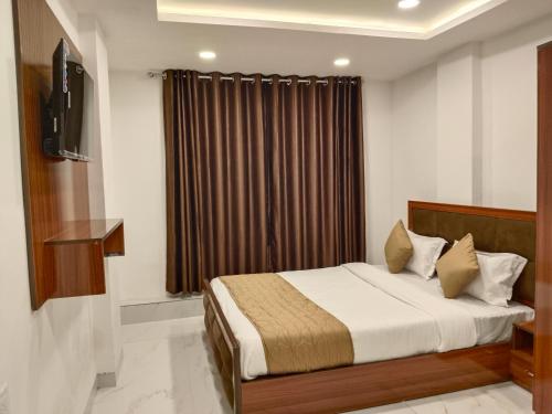 Un dormitorio con una cama y una ventana con cortinas. en Hotel Shiv, en Indore