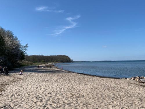 a beach with people standing on it next to the water at Ferienwohnung Pauly in Niesgrau