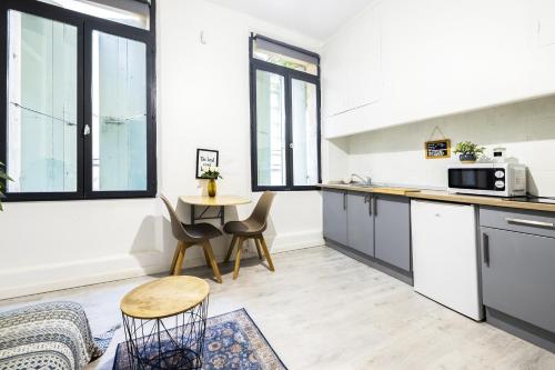 une cuisine et une salle à manger avec une table et des chaises dans l'établissement Comédie 1 - Apt centre ville de Perpignan, à Perpignan