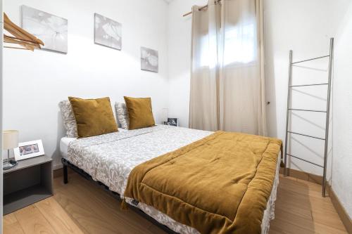 une chambre avec un lit avec des oreillers jaunes dans l'établissement Comédie 2 - Appt en plein centre de Perpignan, à Perpignan