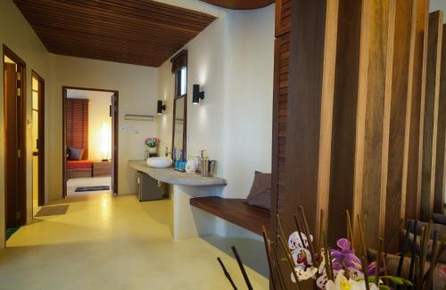 a bathroom with a sink and a bench in a room at Nangyuan Island Dive Resort in Koh Tao