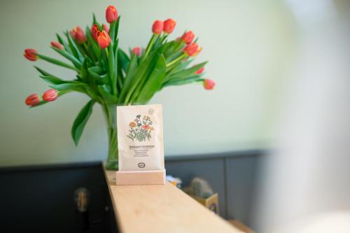 a vase filled with red tulips sitting on a table at Hotel La Bohème in Amsterdam