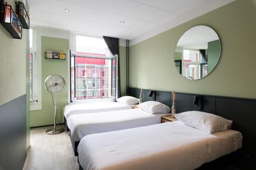 a row of beds in a room with a mirror at Hotel La Bohème in Amsterdam