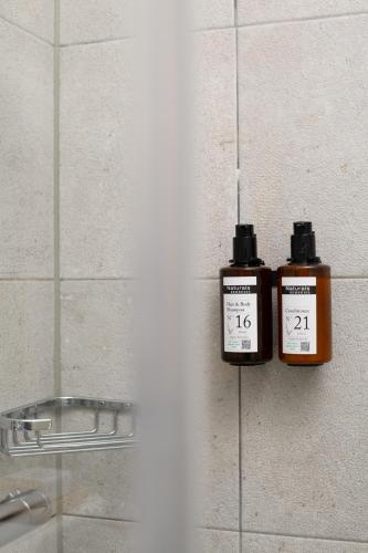 two bottles ofodorizers on the wall of a bathroom at Hotel La Bohème in Amsterdam