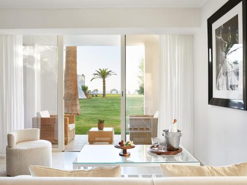 a living room with a couch and a glass table at Grecotel Creta Palace in Rethymno Town