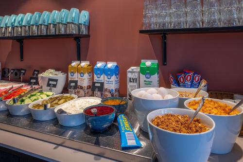 a counter with many bowls of food on a table at Hotel Fridhem in Stockholm