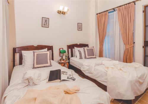 two beds in a room with white sheets at Yesterday Hotel in Chiang Mai