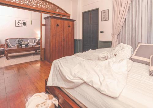 a bedroom with a large bed with white sheets at Yesterday Hotel in Chiang Mai