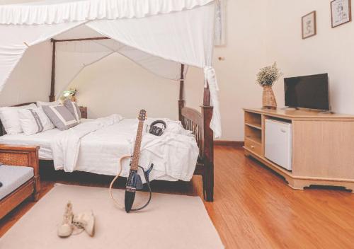 a bedroom with a bed with a guitar and a tv at Yesterday Hotel in Chiang Mai