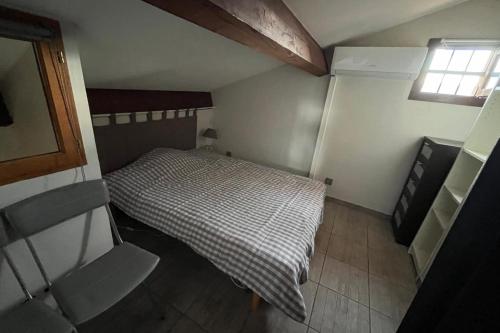 une petite chambre avec un lit et une fenêtre dans l'établissement Cosy flat with pool and sea view, à Saint-Cyprien