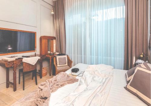 a bedroom with a bed and a desk and a television at Yesterday Hotel in Chiang Mai