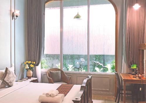 a bedroom with two beds and a large window at Yesterday Hotel in Chiang Mai