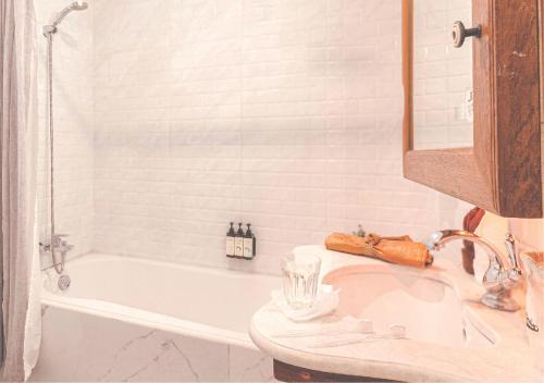 a bathroom with a white tub and a sink and a bath tub at Yesterday Hotel in Chiang Mai