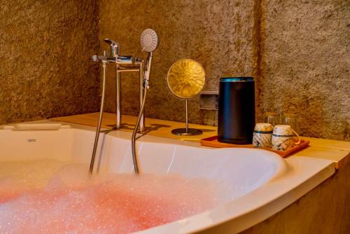 a bath tub filled with water with a sink at R resident resort in Phetchaburi