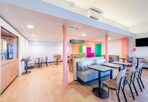 una stanza con tavoli, sedie e una pescheria di B&B HOTEL Strasbourg Aéroport a Holtzheim
