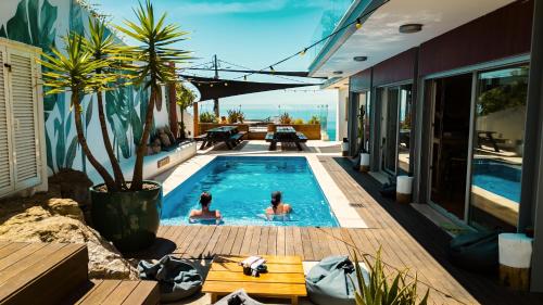two people in the swimming pool of a house at The Salty Surf & Yoga in Ericeira