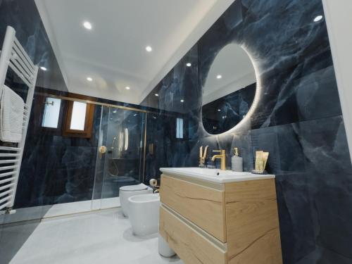 a bathroom with a sink and a toilet and a mirror at Butera 505-Luxury Suites in Bagheria