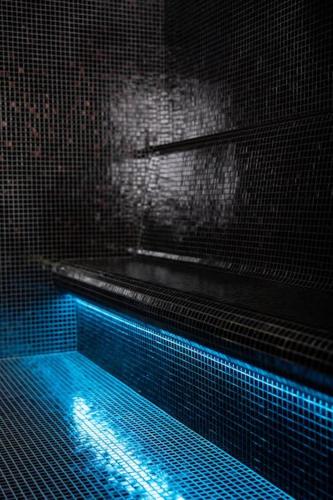 - une piscine avec des lumières bleues dans une chambre dans l'établissement Maison curieuse - hammam et spa, à Épisy