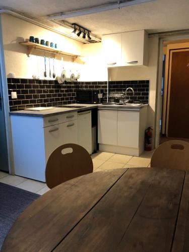 a kitchen with white cabinets and a wooden table at B&B Chalet Les Frenes in Chamonix-Mont-Blanc