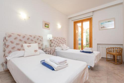 a bedroom with two beds and a chair at Villa Mar y Tierra in La Cabaneta