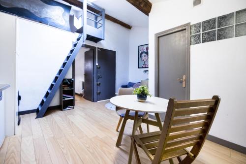un salon avec une table et un escalier dans l'établissement Comédie 3 - Appt centre historique de Perpignan, à Perpignan