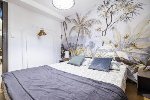 une chambre avec un grand lit avec des oreillers bleus dans l'établissement Comédie 3 - Appt centre historique de Perpignan, à Perpignan