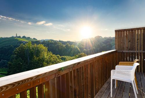 a white chair sitting on a deck with the sun in the sky at Kellerstöckel Steinbach in Gamlitz