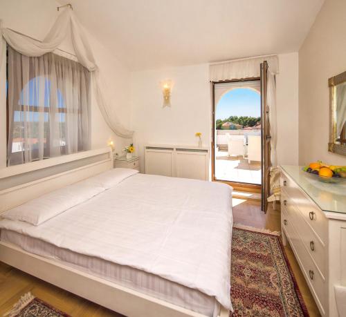 a bedroom with a large bed and a large window at Villa Vulin Veruda in Pula