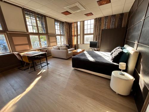 a bedroom with a bed and a living room at Stylish independent Studio S1, City Centre Dordrecht in Dordrecht