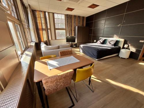 a room with a bed and a table and a bed and a couch at Stylish independent Studio S1, City Centre Dordrecht in Dordrecht