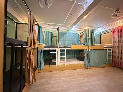 Habitación con 2 literas y cortinas azules. en Ha Giang Safari Hostel & Motorbikes, en Ha Giang