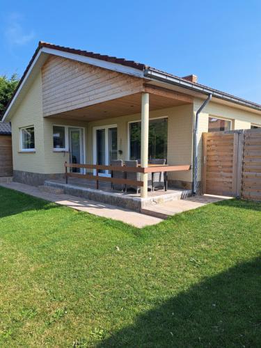 een huis met een veranda met een picknicktafel erop bij Pavillon du golf in De Haan