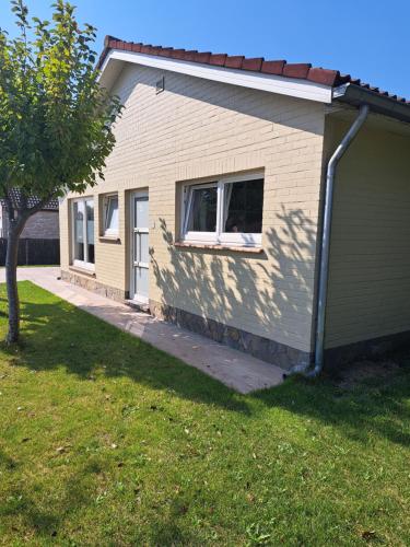 een klein huisje met een boom ernaast bij Pavillon du golf in De Haan