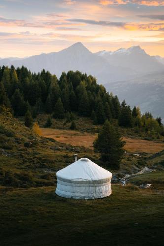 a white object on top of a hill with mountains at Alp Jurte Skihütte Feldis in Feldis